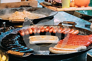 Potatoes And Sausages Fried On A Frying Pan. Traditional Christmas Dish Of Street Food On Streets Of Europe