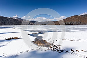 Potatso National Park or Pudacuo National Park during winter with mountain and frozen lake scenery with snow covered ground