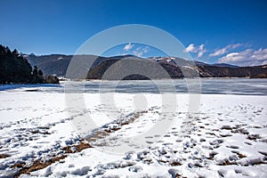 Potatso National Park or Pudacuo National Park during winter with mountain and frozen lake scenery with snow covered ground