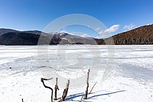 Potatso National Park or Pudacuo National Park during winter with mountain and frozen lake scenery with snow covered ground