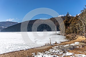 Potatso National Park or Pudacuo National Park during winter with mountain and frozen lake scenery with snow covered ground