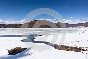 Potatso National Park or Pudacuo National Park during winter with mountain and frozen lake scenery with snow covered ground