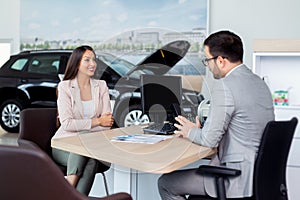 Potential female vehicle buyer carefully listening to car dealer