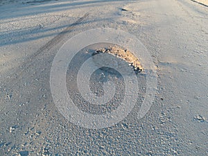 Pothole on the asphalt. A pit formed on the road surface.