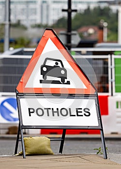 Potholes hazard warning sign dangerous road conditions