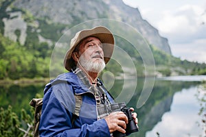 Portrét aktívneho staršieho muža na turistike v jesenných horách.