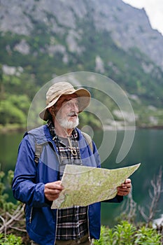 Portrét aktivního staršího muže turistiky v podzimních horách.