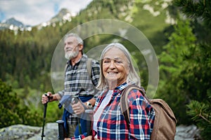 Potrait of active senior woman hiking with husband in autumn mountains.