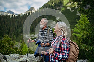 Potrait of active senior woman hiking with husband in autumn mountains.