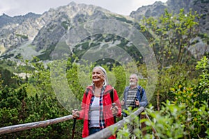 Portrét aktívnej staršej ženy na turistike s manželom v jesenných horách.