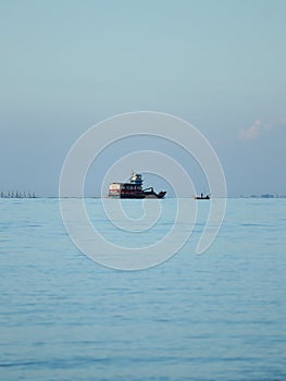 Potrait of a fishing boat at the horizon photo