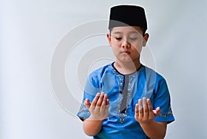 potrait of handsome asian muslim boy with praying expression