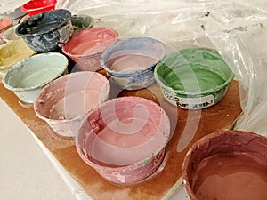 Pots of colored paints in an artist studio.