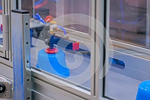 Pots on conveyor belt of plastic injection molding machine with robotic arm photo