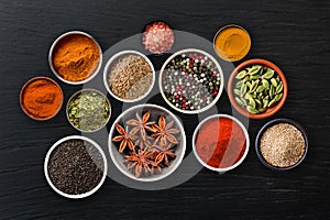 Pots of exotic spices on a slate background.