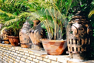 Pots made in Vietnam and standing on the territory of the pagoda among green trees and shrubs with posterization effect photo