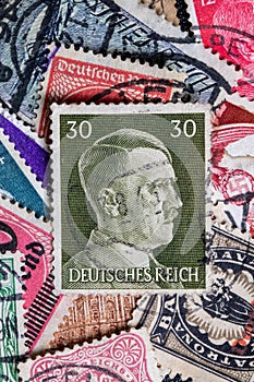 Potsdam, Germany - APR 26, 2022. A stack of old German stamps from the Third Reich and on it a stamp with printed portrait of