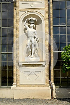 POTSDAM, GERMANY. The man`s sculpture with a basket on the head in a niche of the Hothouse palace. Park of San Sushi