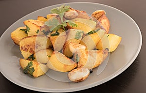 Pottatto fry garnished with coriander in a plate.