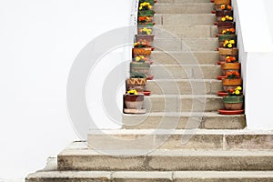 Potted flowers on stairs and white walls at Cozia Monastery in Romania