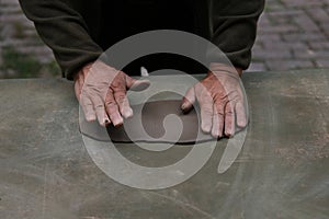 Potter artisan and artist shaping wet clay on the desk with his hands