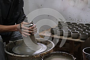 Potter artisan and artist shaping wet clay on the pottery wheel