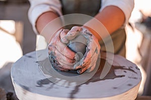 Potter is creating earthenware on potter`s wheel.