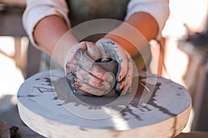 Potter is creating earthenware on potter`s wheel.