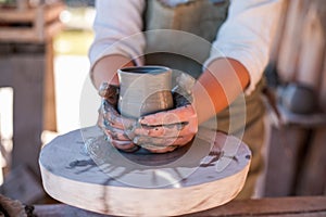 Potter is creating earthenware on potter`s wheel.