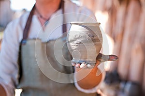 Potter is creating earthenware on potter`s wheel.