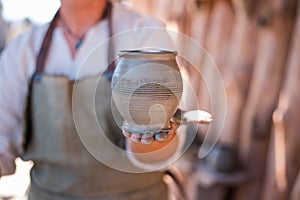 Potter is creating earthenware on potter`s wheel.