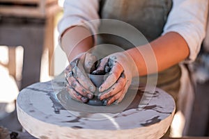 Potter is creating earthenware on potter`s wheel.