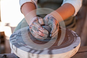 Potter is creating earthenware on potter`s wheel.