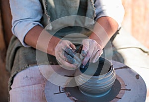 Potter is creating earthenware on potter`s wheel.