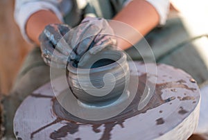 Potter is creating earthenware on potter`s wheel