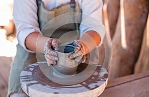 Potter is creating earthenware on potter`s wheel.