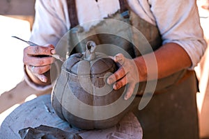 Potter is creating earthenware on potter`s wheel.