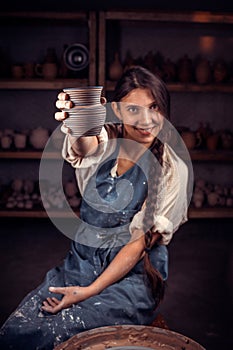 Potter female admires the work done in a pottery workshop. Pottery workshop.