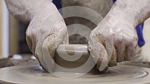 Potter forms plate out of clay. Stock footage. Men`s hands of professional Potter form container of clay on Potter`s