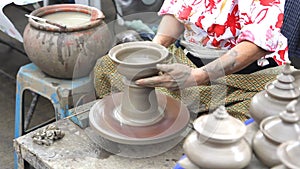 Potter hands making in clay on pottery wheel