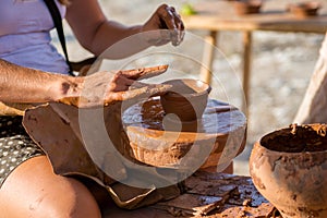 Potter hands making in clay on pottery wheel. makes the pot.