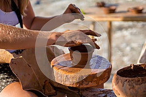 Potter hands making in clay on pottery wheel. makes the pot.