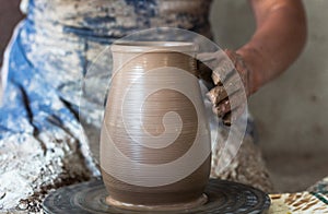 Potter hands making in clay on pottery wheel. Potter makes on the pottery wheel