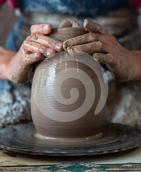 Potter hands making in clay on pottery wheel. Potter makes on the pottery wheel