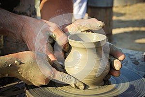 Potter helps the child to make a vase from clay