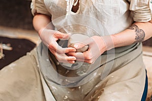Potter holds lump of clay in hands