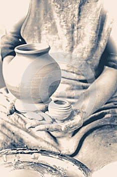 Potter holds made pots. Old vintage style. photo