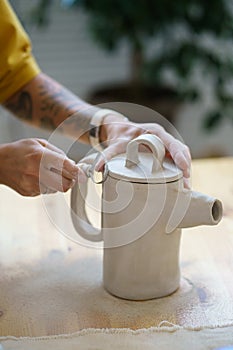 Potter jug creation: female pottery master shaping clay potter kitchenware in ceramics craft studio