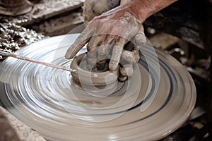 Potter makes on the pottery wheel clay pot.