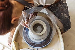 Potter making ceramic pot or vase on pottery wheel